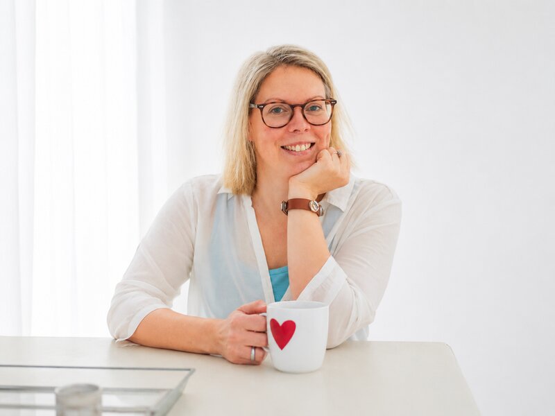 Anya Schmanns lächelt mit einer Tasse in der Hand